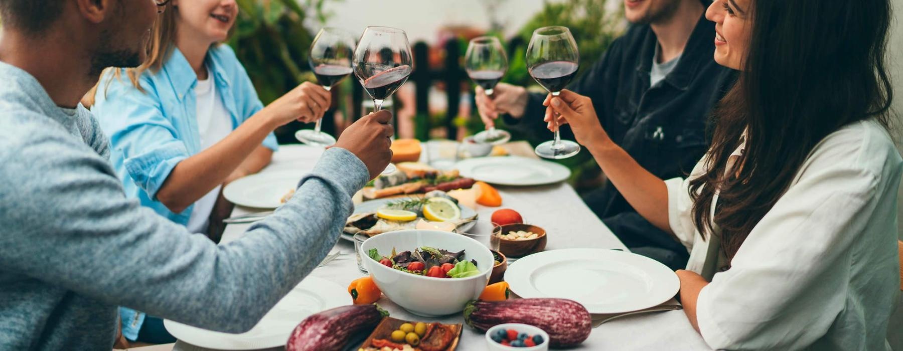 a group of people having a meal around an outdoor table